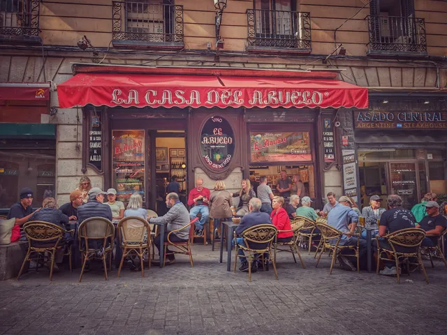Terraza y fachada roja de La Casa del Abuelo, en la calle de la Victoria