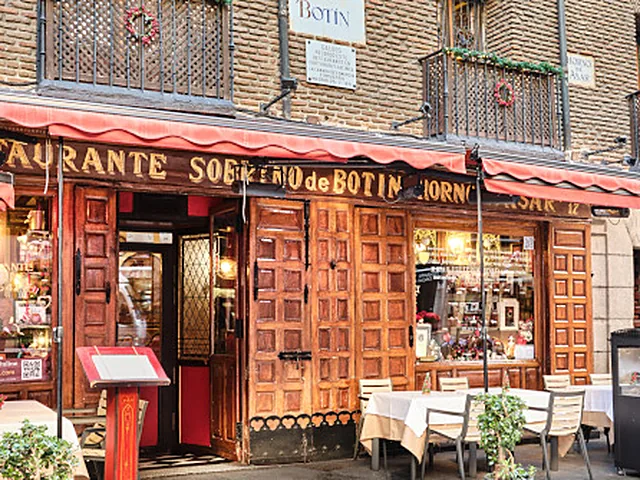 Fachada de madera y toldos rojos de Casa Botín, en la calle de Cuchilleros